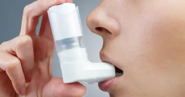 Dłoń trzyma inhalator Ventolin przy ustach. Szybka pomoc w trudnych chwilach.