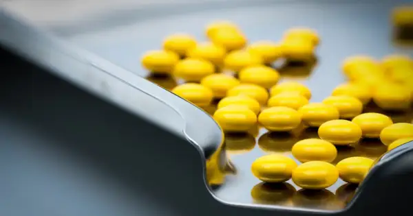 Żółte tabletki, być może tetracyklina, leżą na metalowej tacy.
